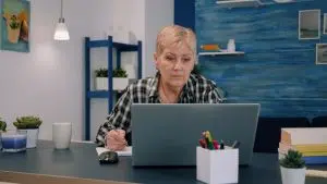 femme-affaires-serieuse-mure-age-moyen-utilisant-ordinateur-portable-tapant-e-mails-ecrivant-ordinateur-portable-travaillant-au-bureau-domicile-vieille-dame-agee-concentree-cherchant-informations-internet-comm