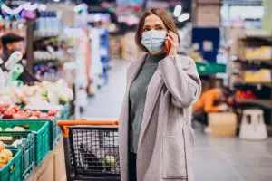 Jeune femme portant un masque facial pour son shopping au rayon epicerie