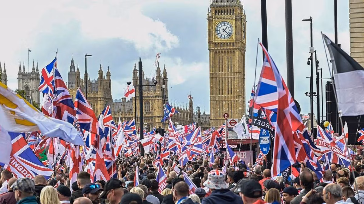 Manifestation à Londres devant le Parlement britannique, avec une foule brandissant de nombreux drapeaux Union Jack et drapeaux anglais.
