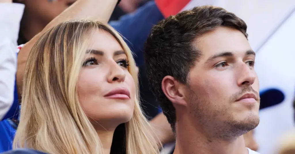 Un homme et une femme regardant vers l’avant lors d’un événement public, semblant attentifs et posés.