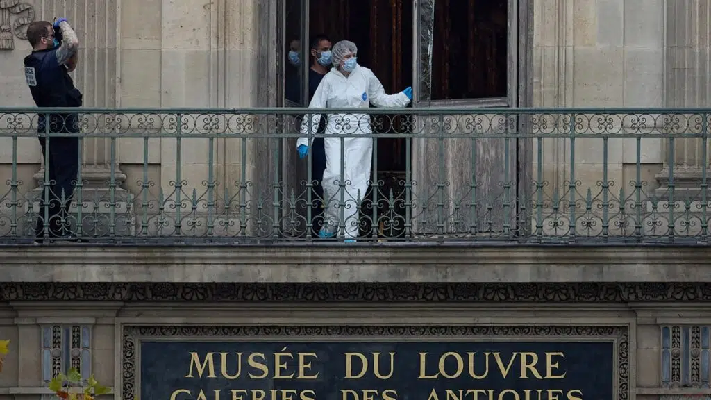 Enquêteurs de la police scientifique sur le balcon du Musée du Louvre après le cambriolage des joyaux impériaux, à Paris.