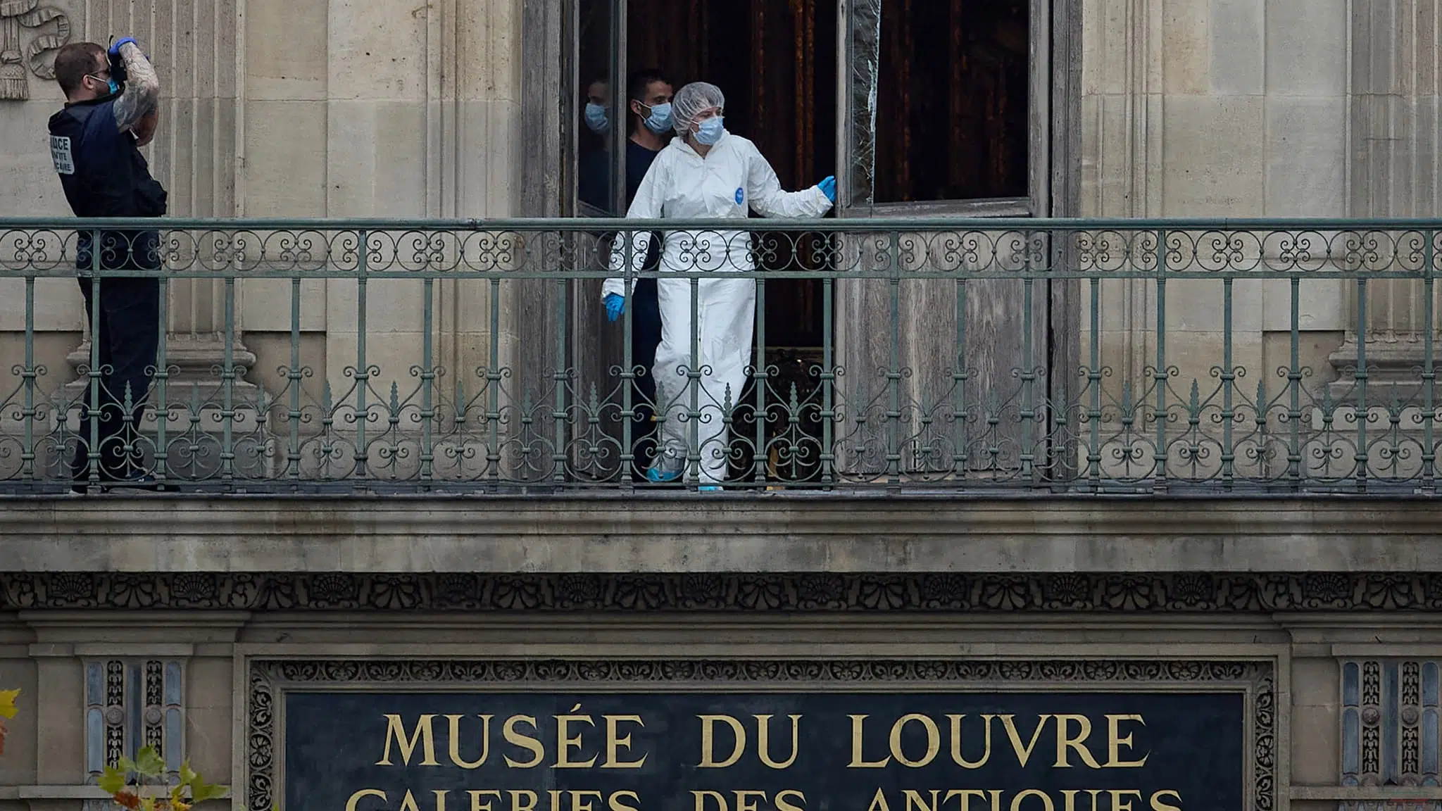 Enquêteurs de la police scientifique sur le balcon du Musée du Louvre après le cambriolage des joyaux impériaux, à Paris.