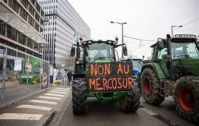 Tracteurs en manifestation avec une pancarte « Non au Mercosur », illustrant la contestation agricole en France contre l’accord UE–Mercosur.