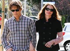 Couple de célébrités marchant dans la rue sans mise en scène médiatique, illustrant une présence publique discrète.