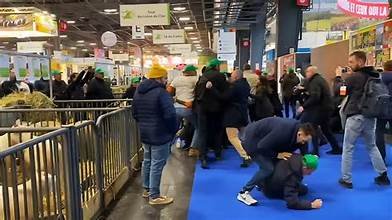 Bagarre entre plusieurs personnes dans une allée du Salon de l’Agriculture, avec des visiteurs et des exposants se bousculant.