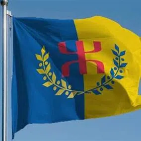 Drapeau kabyle bleu et jaune avec le symbole berbère rouge au centre, flottant au vent.