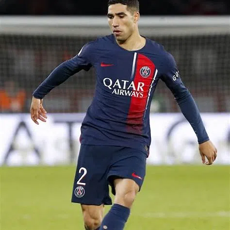 Achraf Hakimi, défenseur du PSG, en action lors d’un match avec le maillot bleu et rouge.