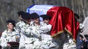 Des militaires français portent un cercueil recouvert du drapeau tricolore lors d’une cérémonie d’hommage.