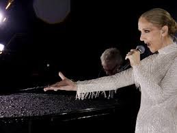 Céline Dion chante sur scène en tenant un micro à la main