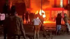 Des manifestants se rassemblent de nuit près d’un feu pendant des troubles survenus à Cuba.