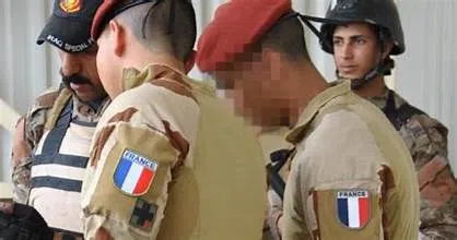 Des militaires français en uniforme échangent avec des membres des forces locales dans un contexte d’opération au Moyen-Orient.