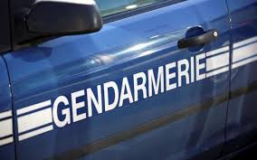 Gros plan sur la portière d’un véhicule de gendarmerie bleu avec l’inscription GENDARMERIE en blanc.