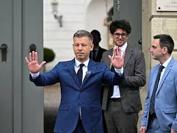 Photo de Péter Magyar devant un bâtiment officiel en Hongrie, saluant alors qu’il s’exprime sur la ligne migratoire du pays