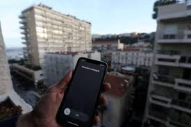 Smartphone affichant un appel inconnu dans un environnement urbain
