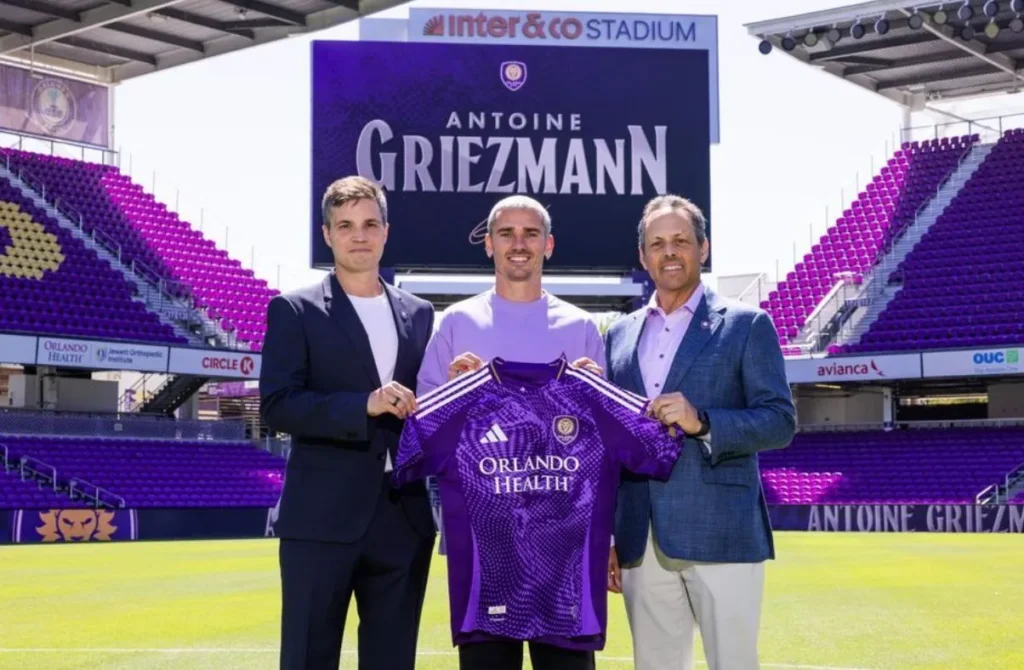 Antoine Griezmann posant dans un stade avec un maillot d’Orlando City lors d’une présentation aux États-Unis.