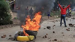 Manifestants au Kenya devant des pneus en feu lors de protestations contre la hausse des prix des carburants.