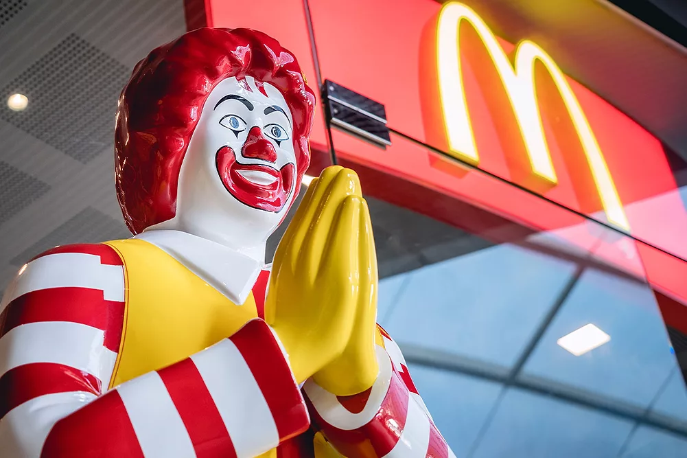 Statue de Ronald McDonald devant un restaurant McDonald’s, alors que des clients signalent des débits inexpliqués de points fidélité sur leurs comptes.