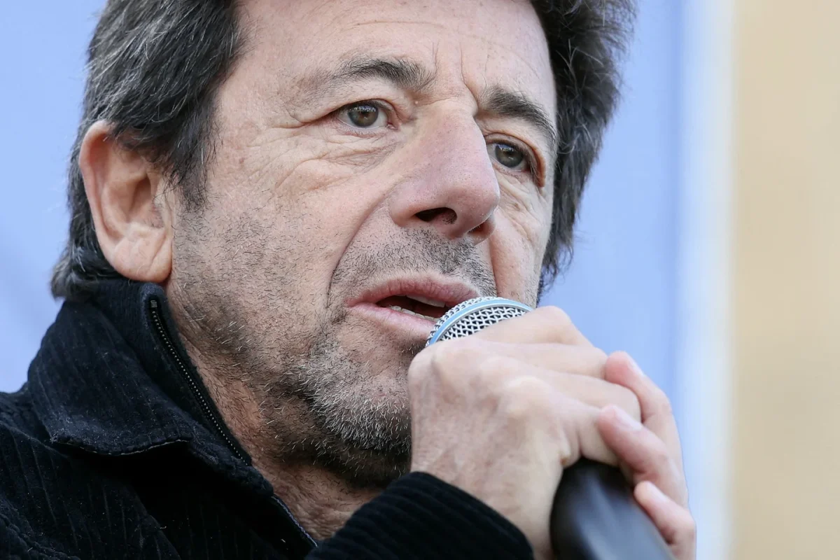 Patrick Bruel tenant un micro lors d’une prise de parole publique.