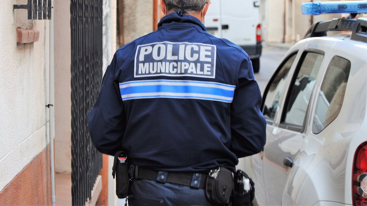Agent de police municipale devant un véhicule de service, illustration de l’enquête ouverte après l’incendie ayant touché les locaux de la police municipale de Céret dans les Pyrénées-Orientales.