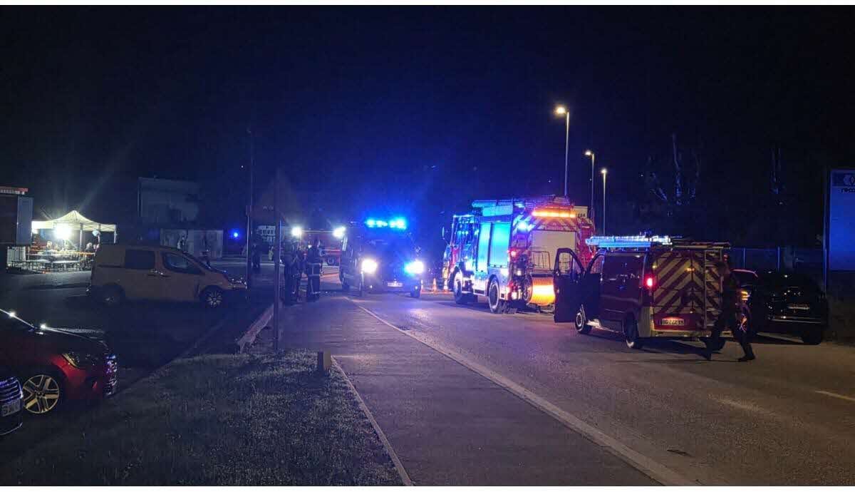 Des véhicules de pompiers et de secours stationnés de nuit dans une zone industrielle à Voglans après l’explosion survenue lors d’un incendie d’usine.