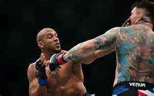 Deux combattants de MMA s’affrontent dans une cage, l’un esquivant un coup de poing lancé par son adversaire.