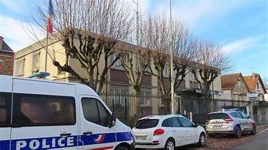 Véhicules de police stationnés devant un bâtiment public à Aulnay-sous-Bois, illustrant une intervention policière liée à une saisie de cannabis.