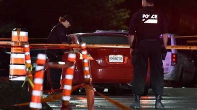 Policiers intervenant de nuit sur une scène bouclée par des rubans de sécurité après une fusillade.