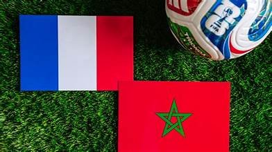 Drapeaux français et marocain posés sur une pelouse avec un ballon de football, illustrant le quart de finale France-Maroc.