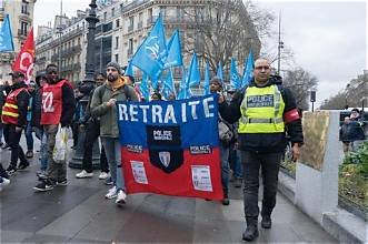 Manifestation de policiers à Paris avec une banderole « Retraite » et des drapeaux syndicaux.