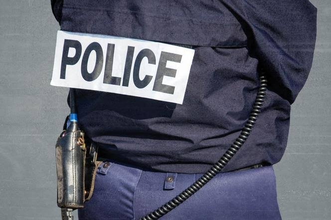 Gros plan sur le dos d’un policier en uniforme, avec l’inscription « POLICE » visible sur son équipement.